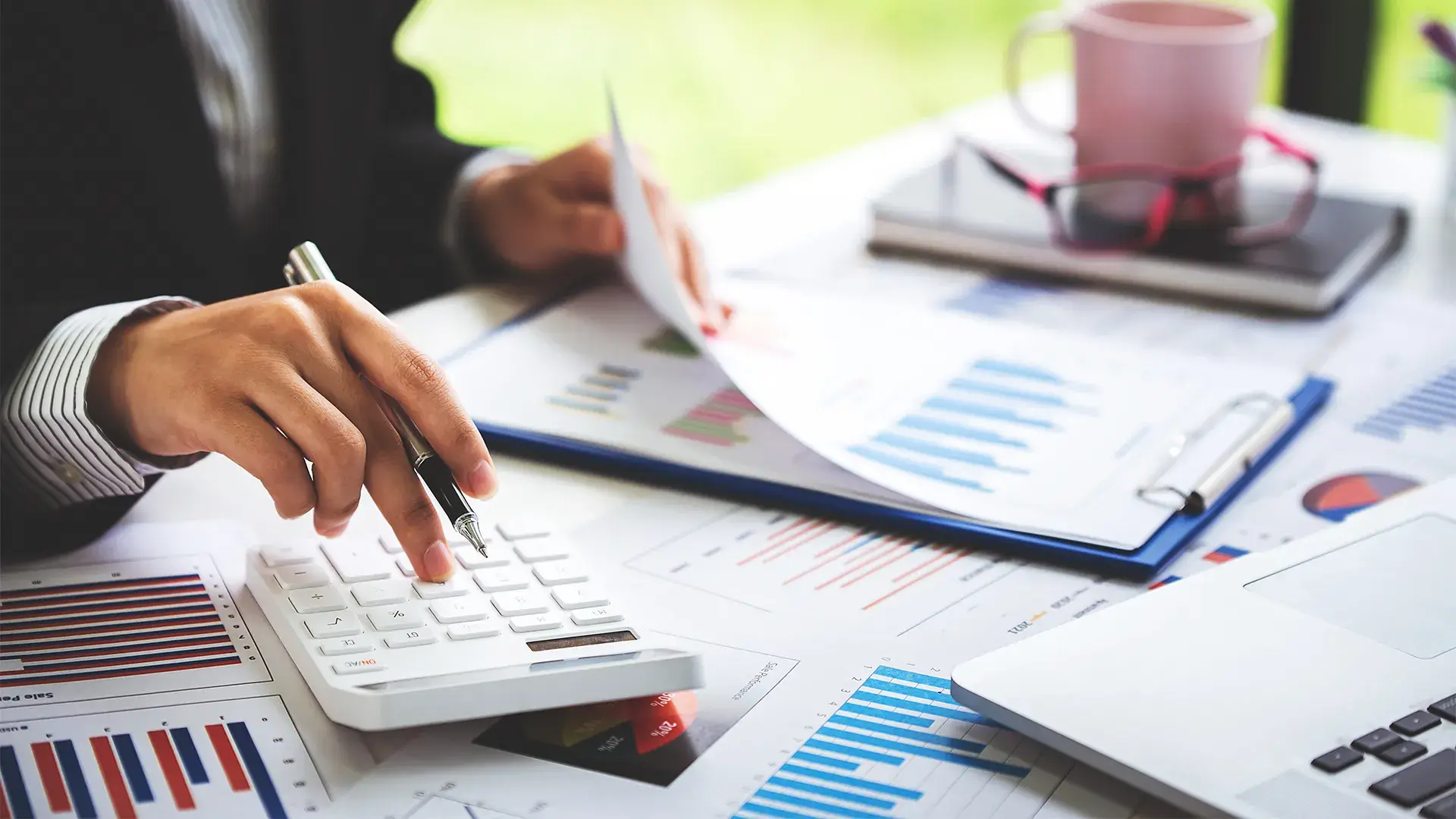 Property Tax in Dubai Guide: Financial advisor calculating net ROI and high rental yields from Dubai real estate investments using charts and a calculator.