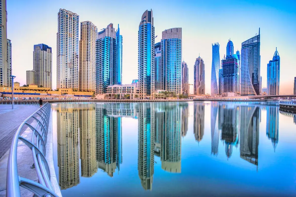 Flawless reflection of luxury residential towers on the tranquil waters of Dubai Marina at dawn, representing premium ready-to-move apartments by Casttio.