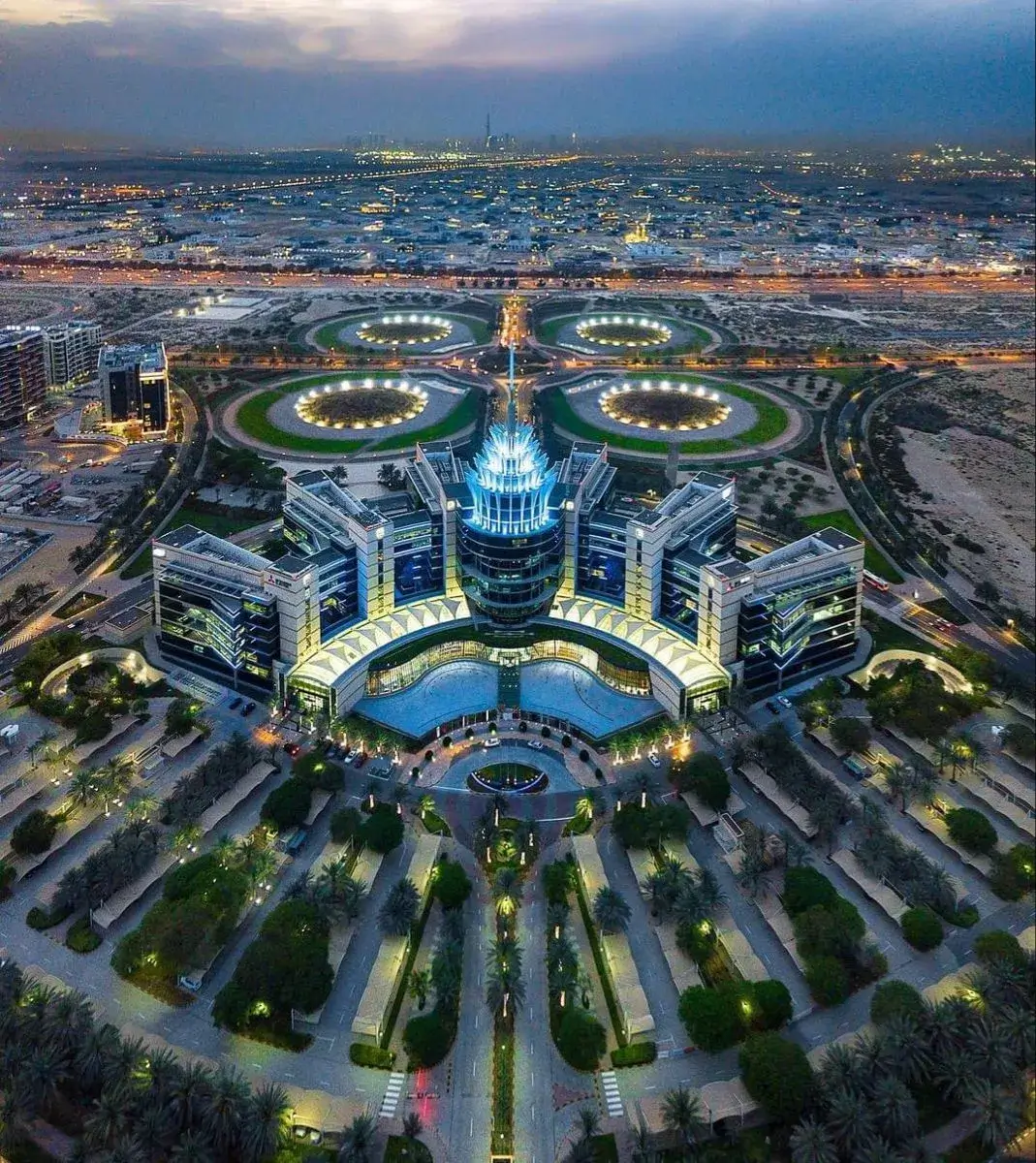 Illuminated Dubai Silicon Oasis headquarters at night, showcasing the symmetrical masterplan and premium corporate hubs available through Casttio.